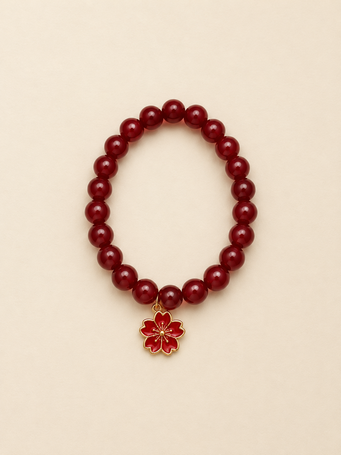 Ruby-red beaded bracelet with a red enamel cherry-blossom charm