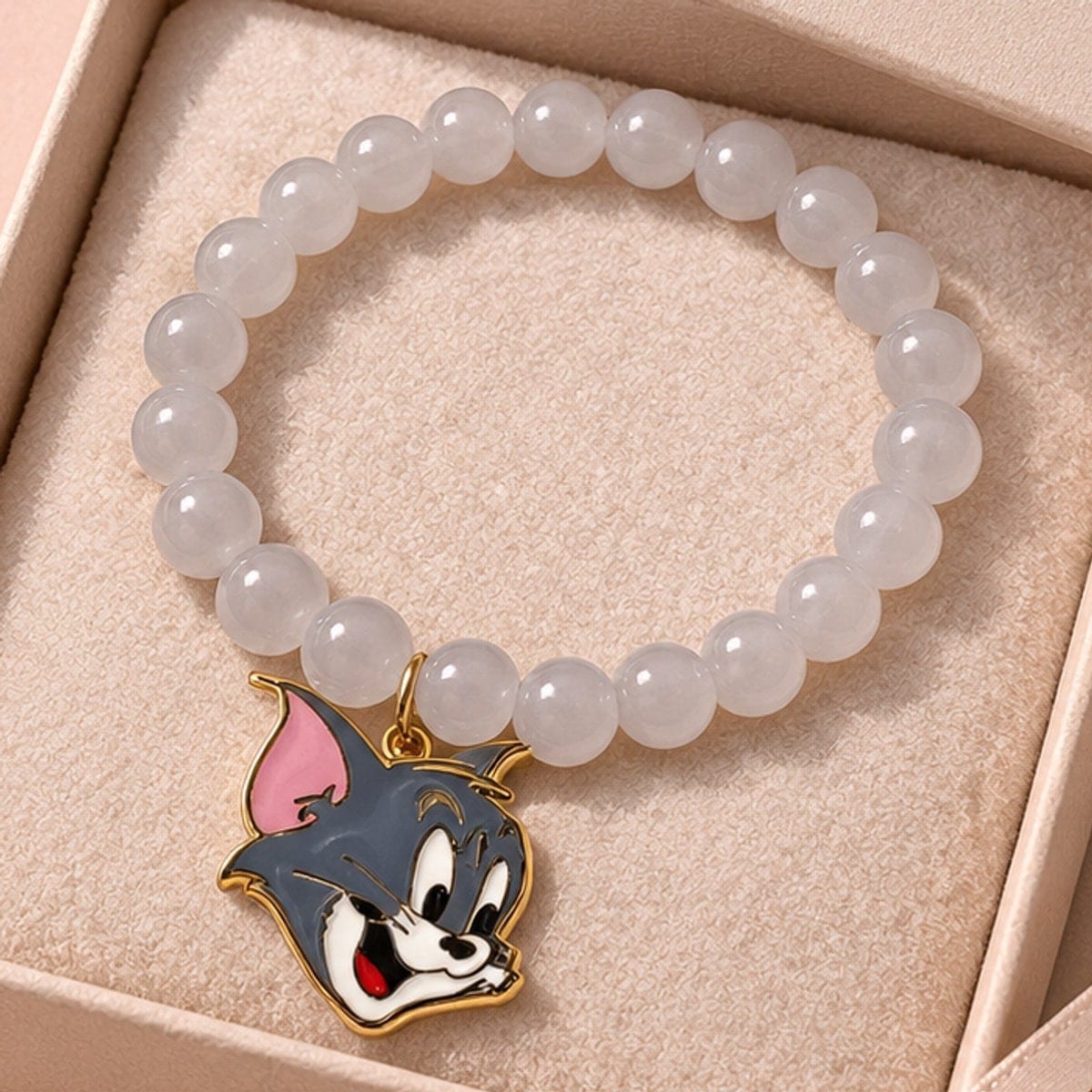 Milky white beaded bracelet with an enamel cat charm in a gift box